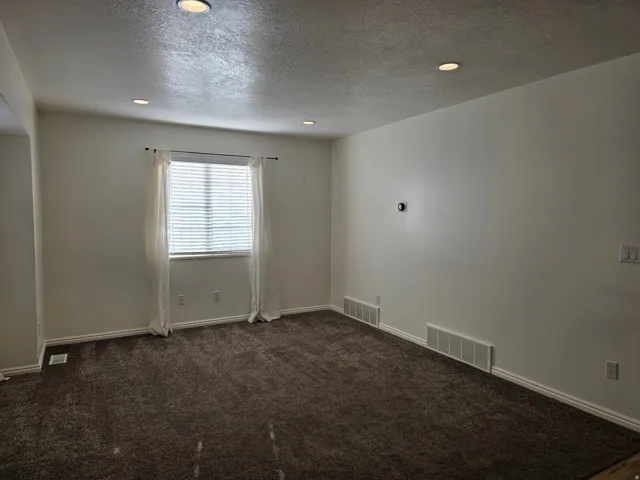 Carpeted room featuring recessed lighting, a window with blinds, and white baseboards