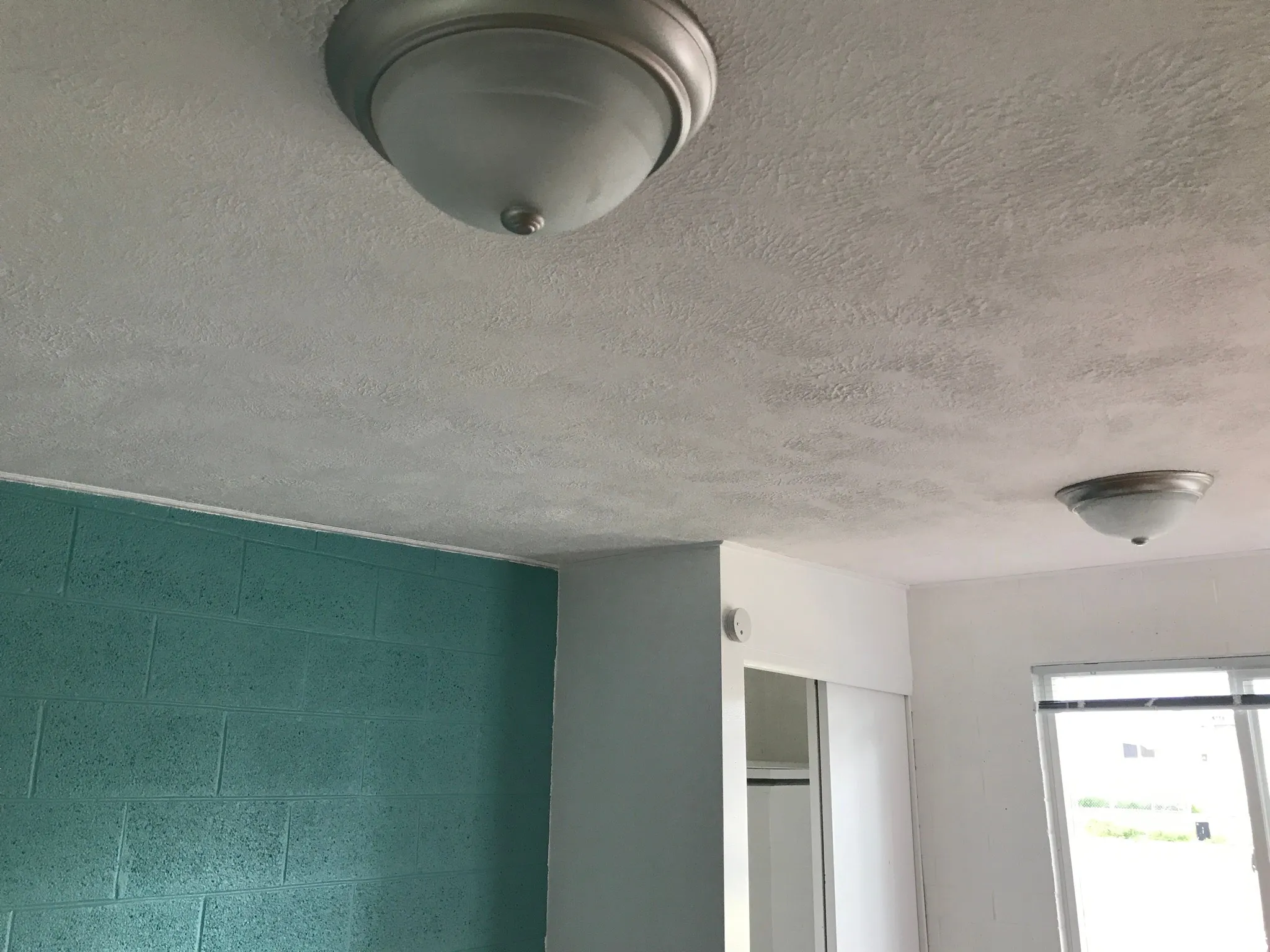 Textured ceiling with two flush-mount light fixtures