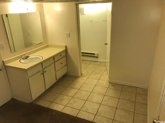 Bathroom featuring a single vanity with an integrated sink, ample counter space, and cabinet storage