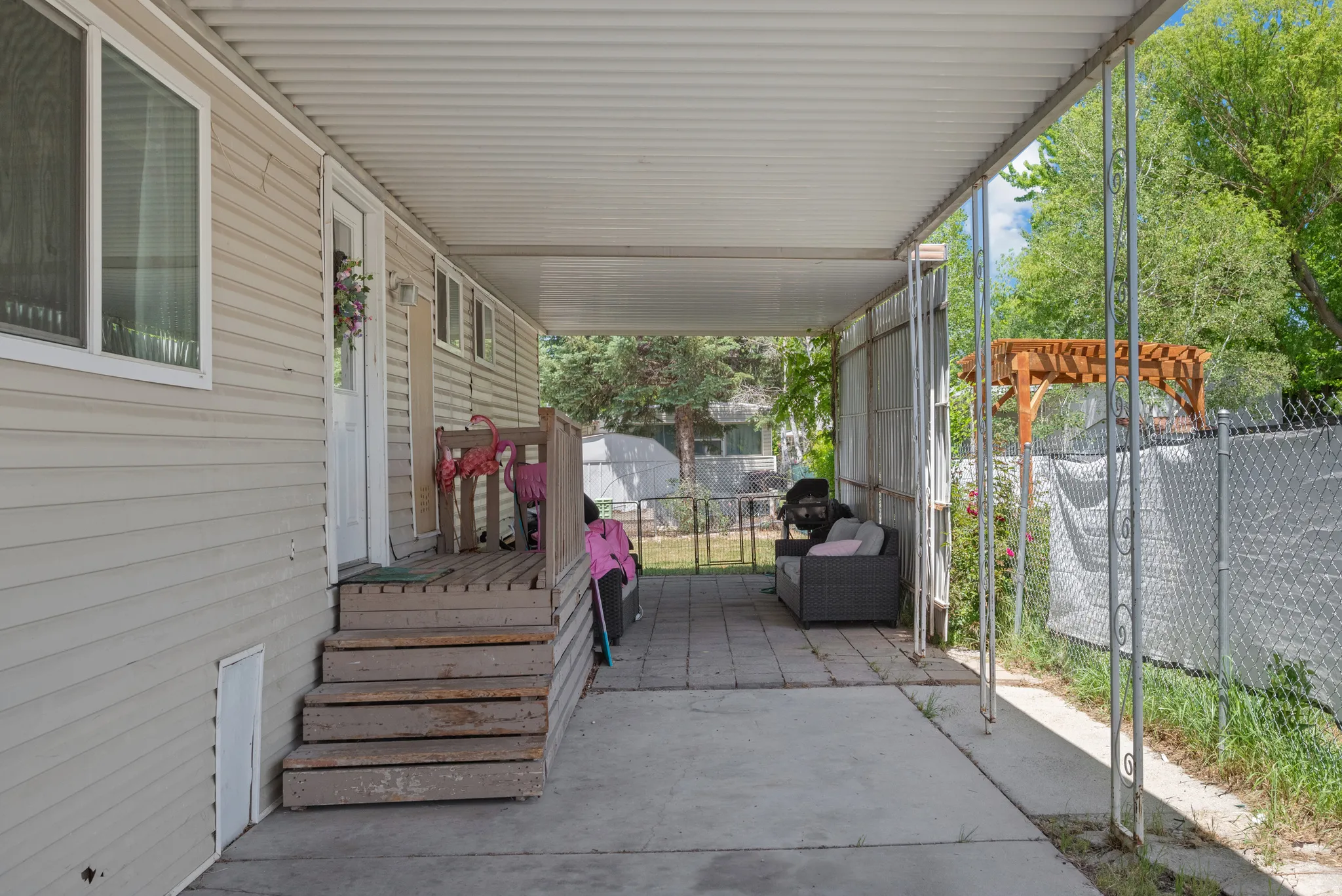 Covered patio area featuring concrete flooring and a partial paver section
