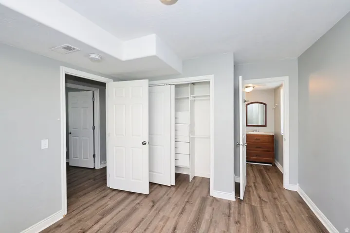Room featuring wood-finish flooring, light gray wall paint, and white baseboards