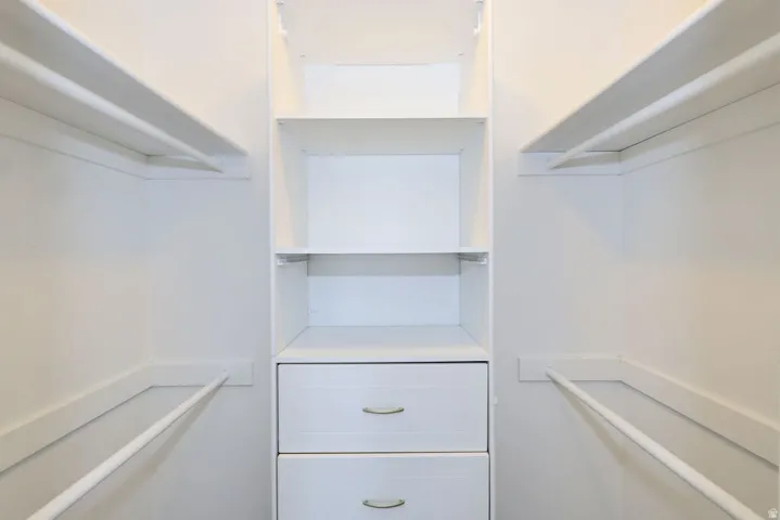 Custom closet system featuring white cabinetry and shelving
