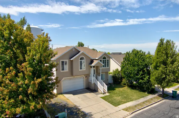 Two-story stucco exterior with a prominent arched window, an attached two-car garage, concrete driveway, and a front lawn