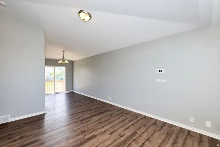 Living area featuring wood-finish flooring, vaulted ceiling, and recessed lighting