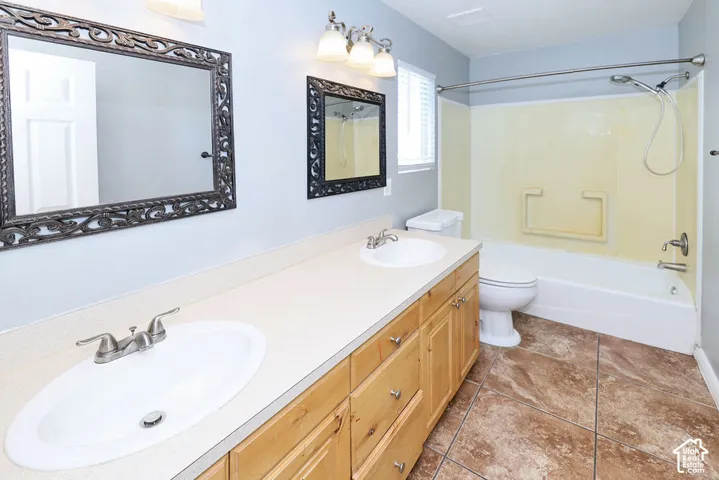 Dual vanity with integrated sinks, light wood-finish cabinetry, and framed mirrors