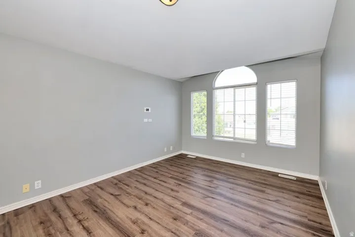 Interior space featuring wood-finish flooring, light gray wall paint, and white baseboards