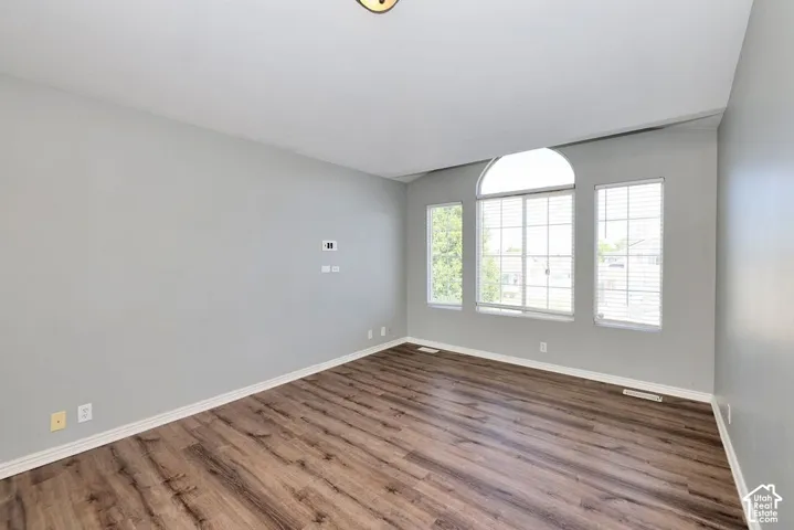Interior space featuring wood-finish flooring, light gray wall paint, and white baseboards