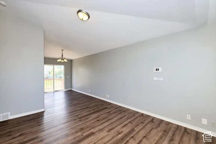 Living area featuring wood-finish flooring, vaulted ceiling, and recessed lighting