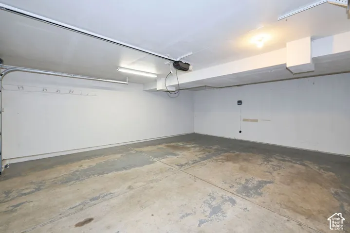 Spacious garage featuring a concrete floor, white painted walls, and overhead lighting