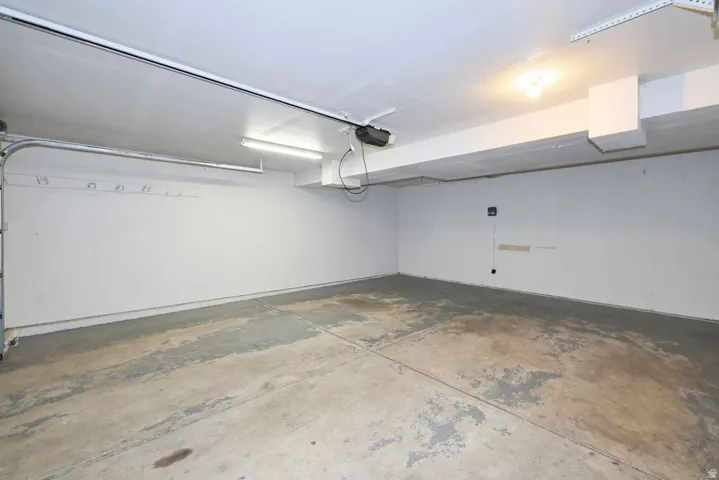 Spacious garage featuring a concrete floor, white painted walls, and overhead lighting