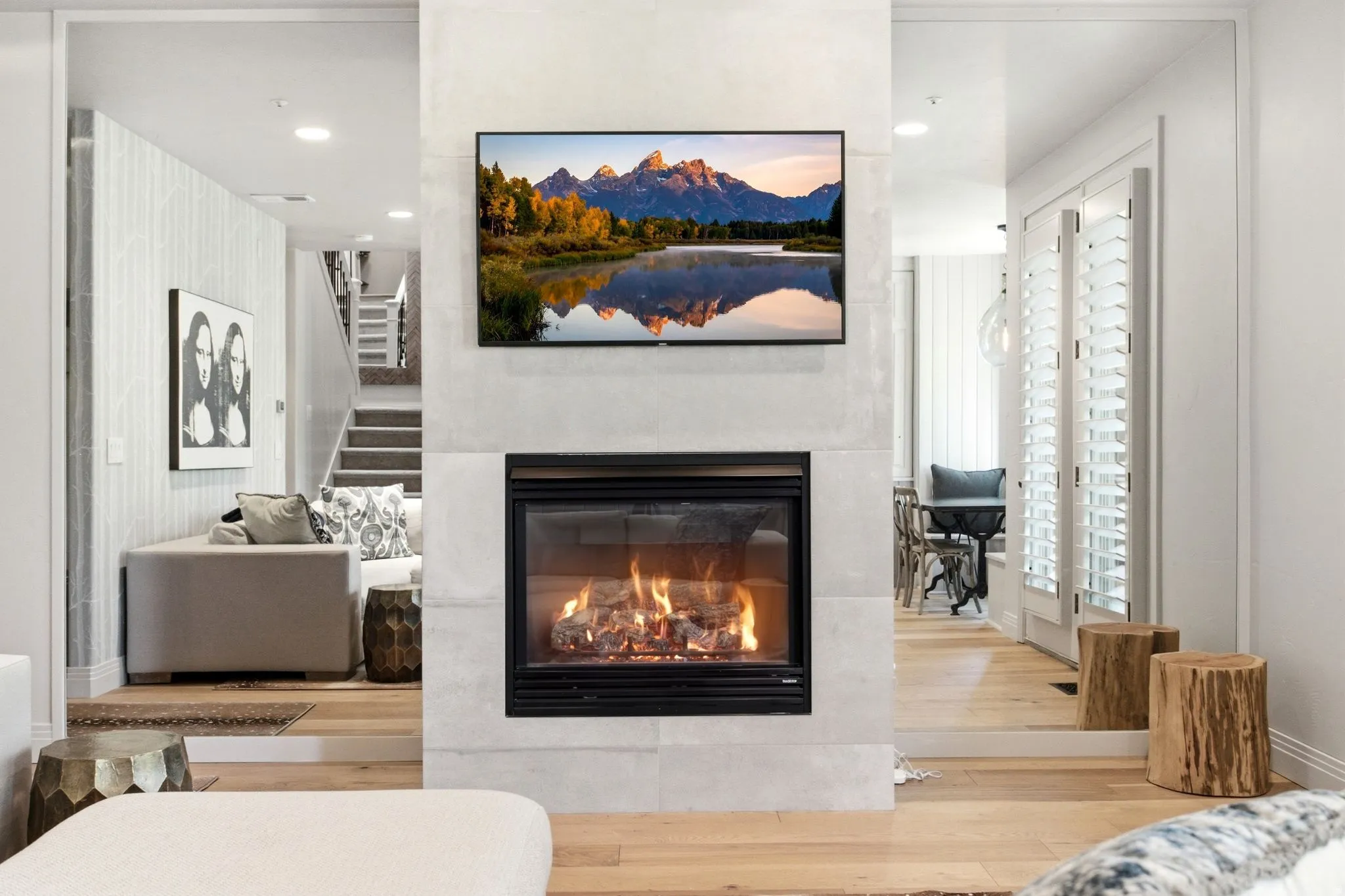 Central fireplace with a light-toned stone surround, integrated flat-screen, and a built-in firebox