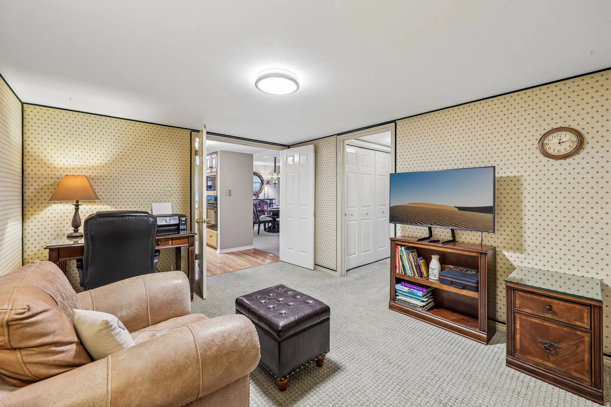 Carpeted room with patterned wallpaper and recessed lighting