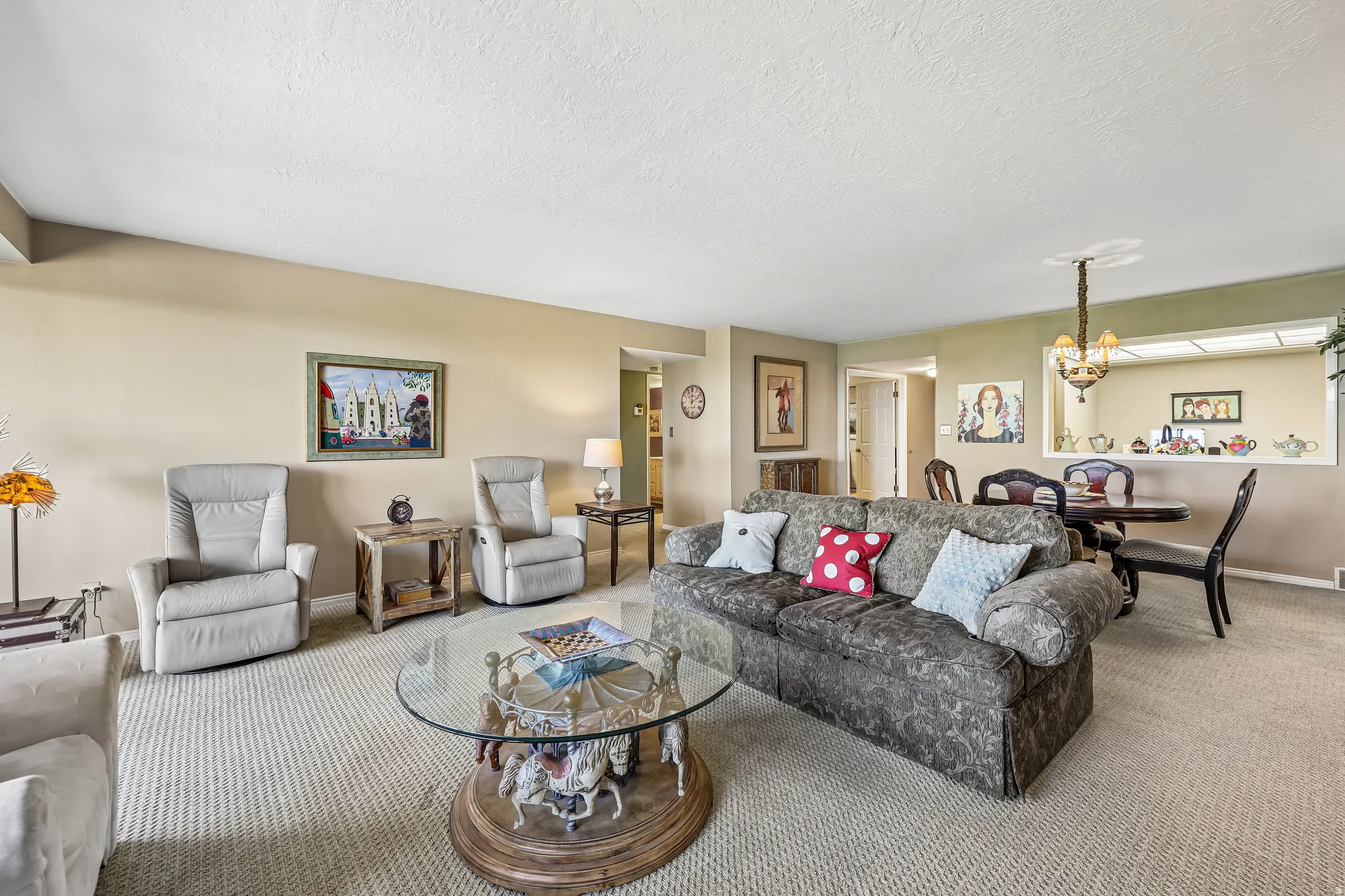 Living area featuring neutral-toned walls and textured carpeting