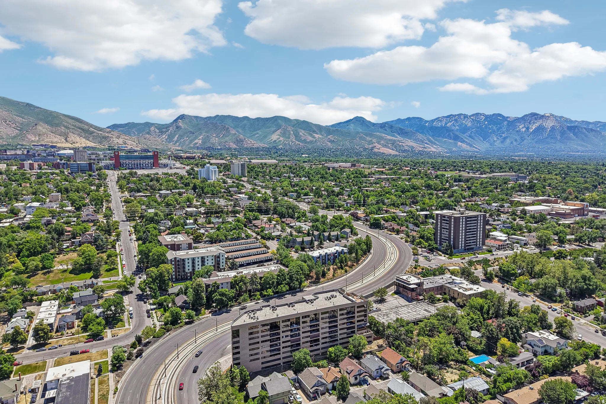 Expansive aerial perspective showcasing a verdant urban landscape with distant mountains