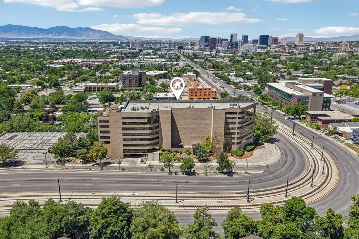 Aerial perspective showcasing a multi-story commercial building with a brick facade and numerous windows