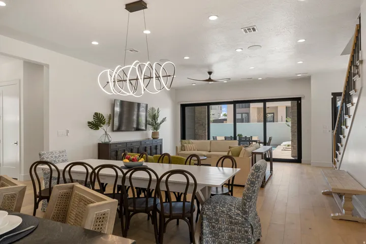 Spacious dining area featuring a linear chandelier, wood-finish flooring, and recessed lighting