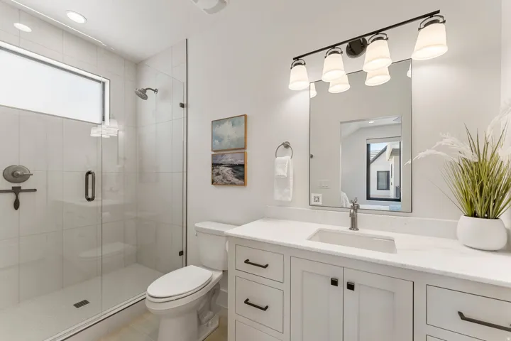 Modern bathroom featuring a glass-enclosed shower with subway tile surround and a transom window