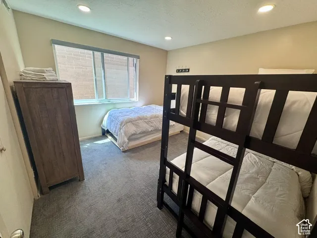 Carpeted room featuring recessed lighting and a window with blinds