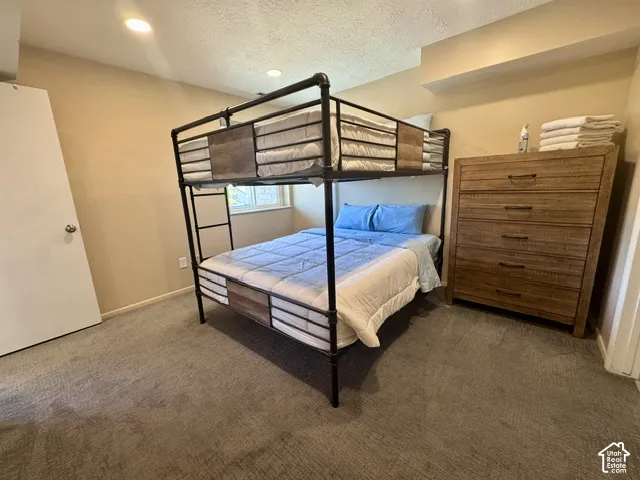 Carpeted room featuring a white door, recessed lighting, and a window
