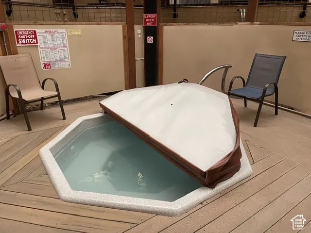 Hexagonal hot tub with a partial cover, set into wood-finish decking