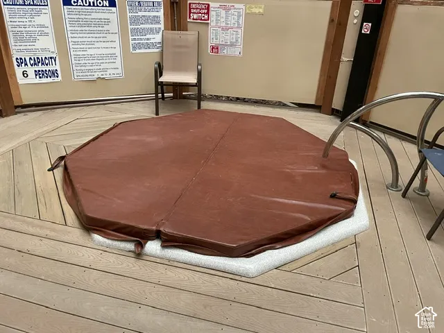 Octagonal spa with a brown thermal cover, set into wood-finish flooring