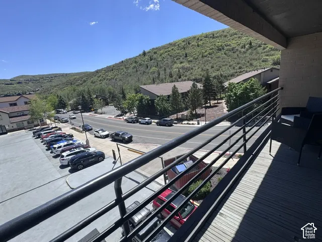 Balcony with wood-finish decking and a black metal railing