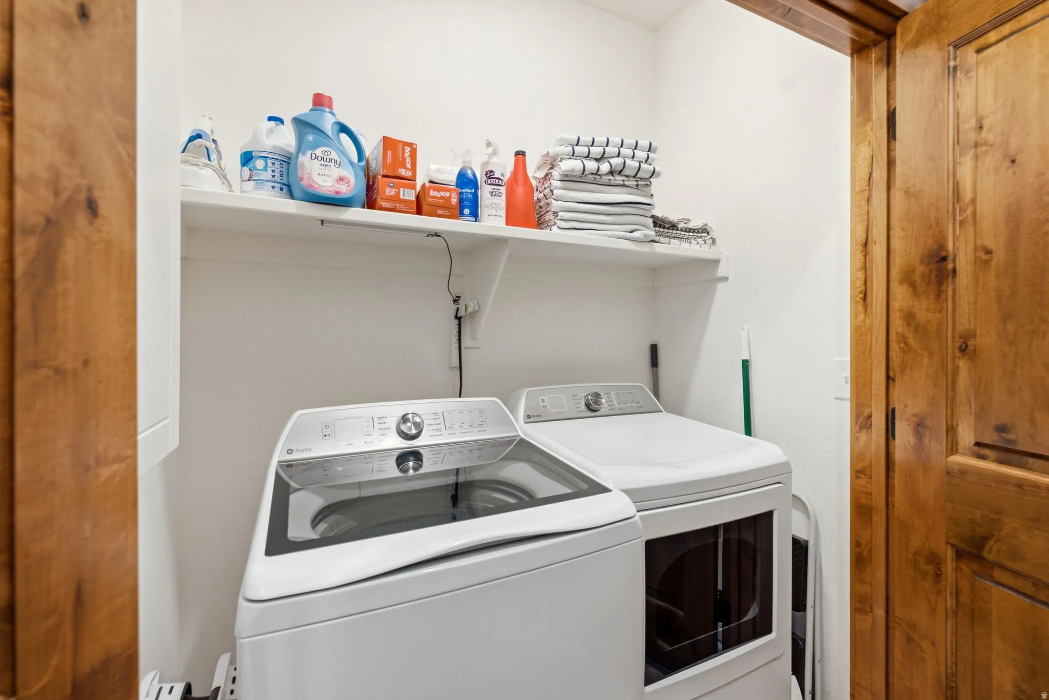 Dedicated laundry area featuring a white top-load washer and front-load dryer
