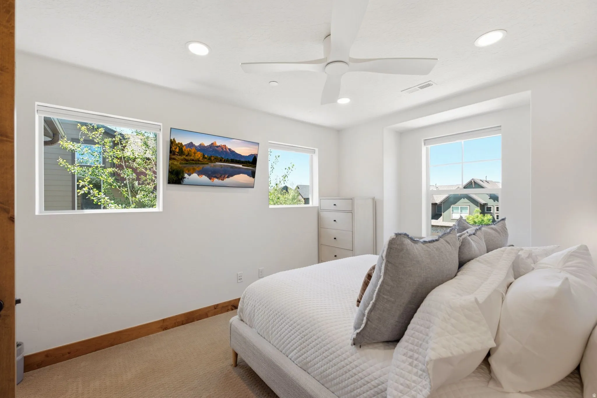 Bright bedroom featuring multiple windows, recessed lighting, and a ceiling fan