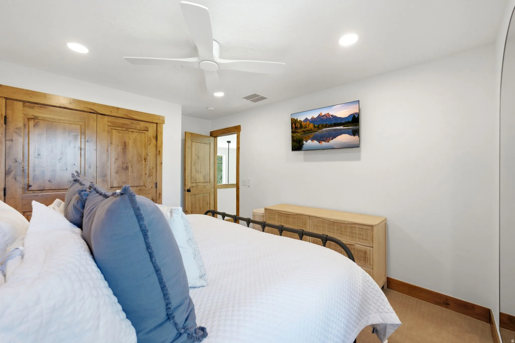 Bedroom featuring wood-finish closet doors, recessed lighting, and a ceiling fan