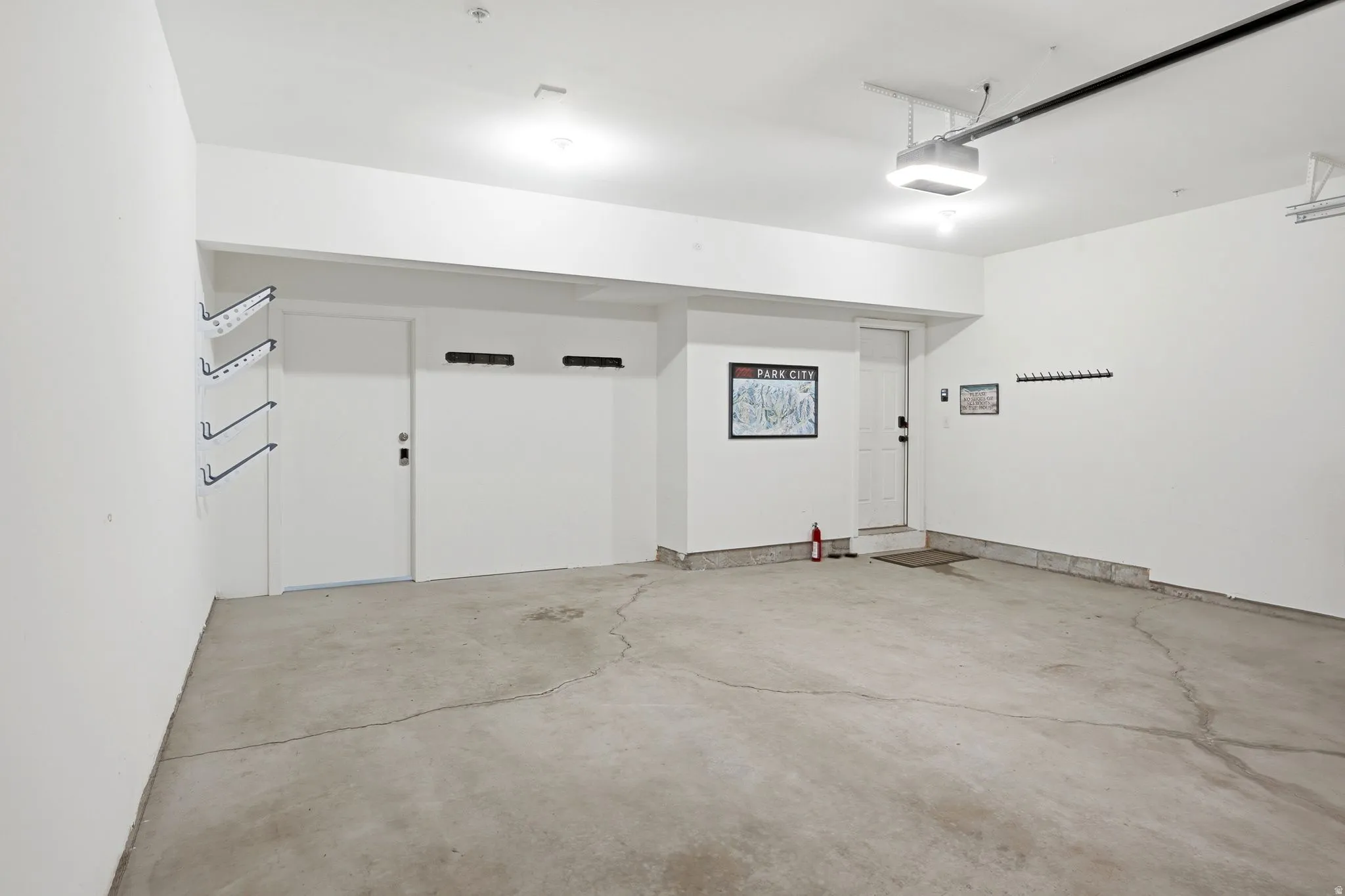 Spacious garage featuring a concrete floor, two entry doors, and built-in wall shelving