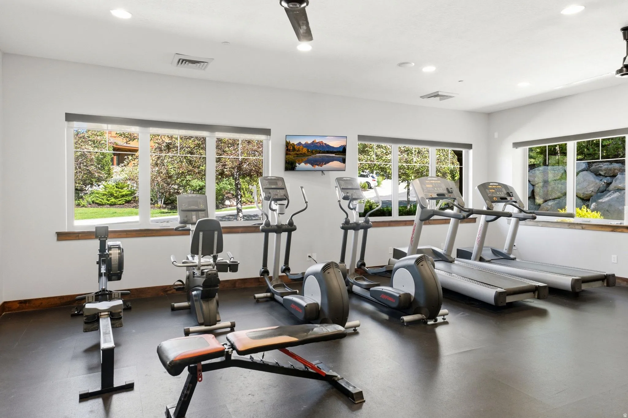 Dedicated fitness room featuring recessed lighting and multiple large windows