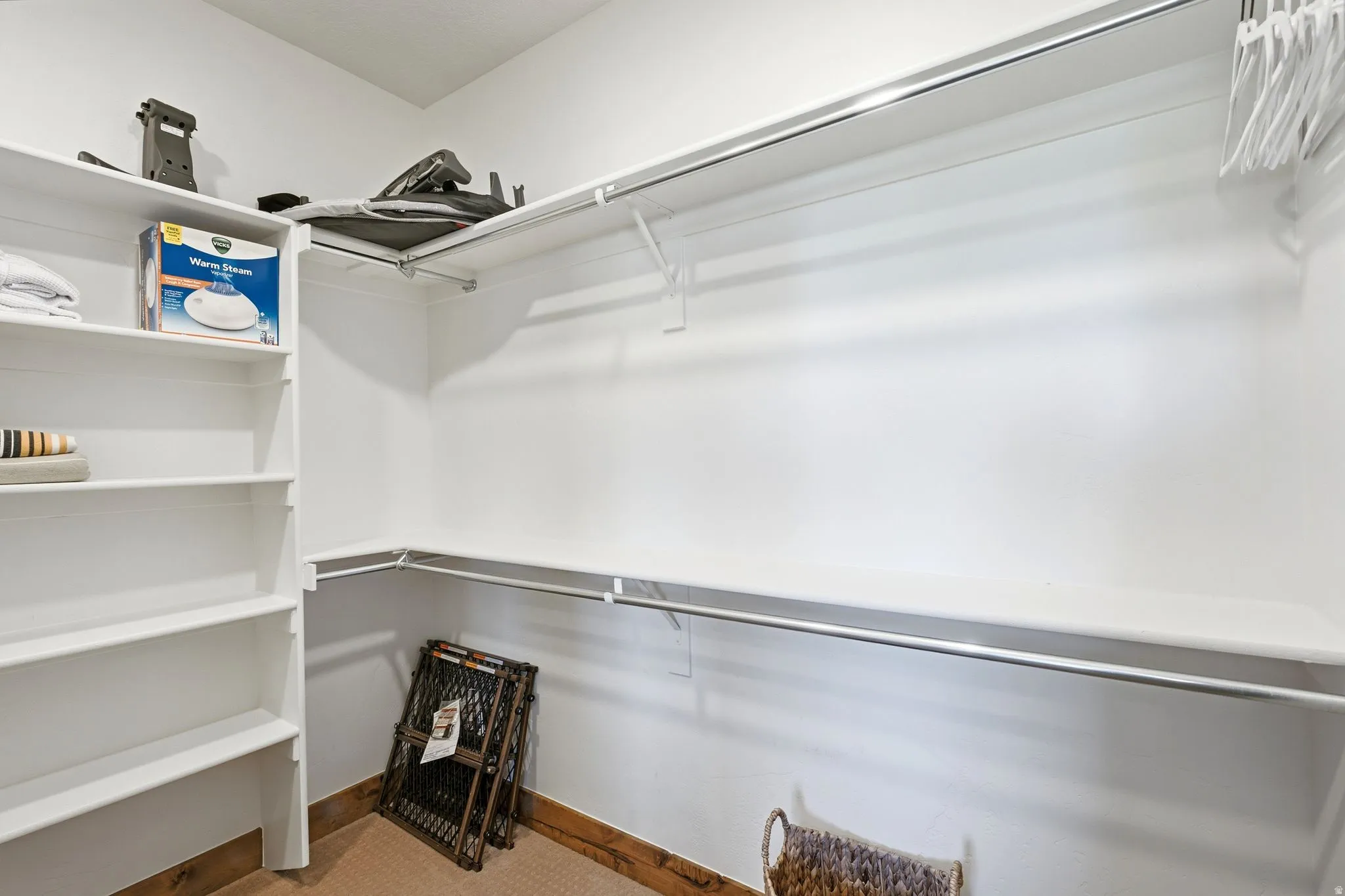 Custom closet system featuring built-in shelving, white walls, and wood-finish trim