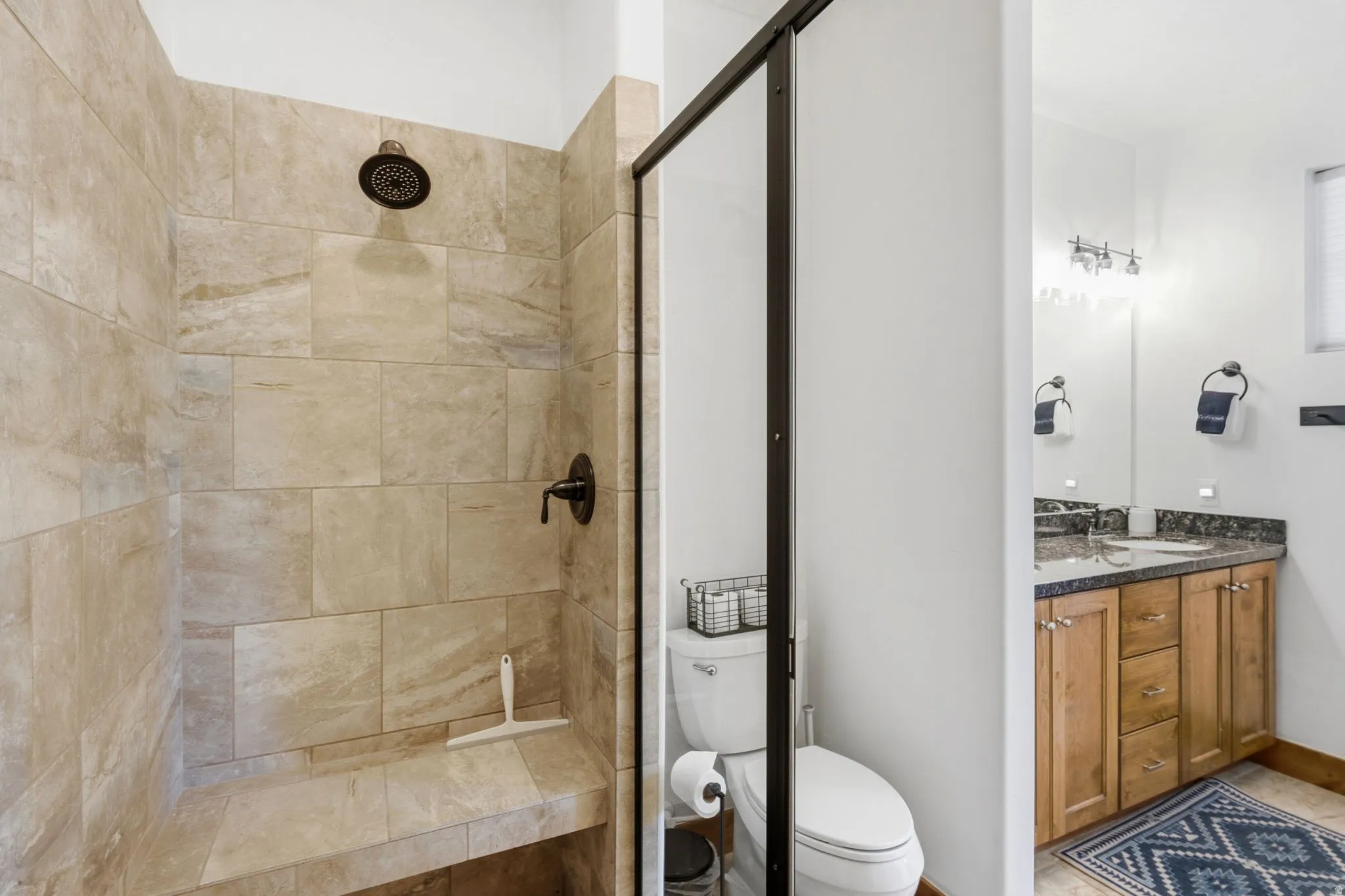 Walk-in shower with textured tile surround and integrated bench seating