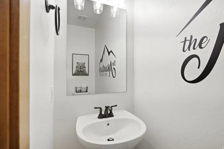 White pedestal sink with a dark bronze-finish faucet