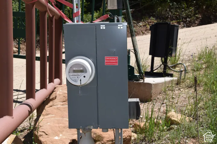 Utility meter and electrical service panel on a concrete pad, accompanied by an electronic gate opener mechanism