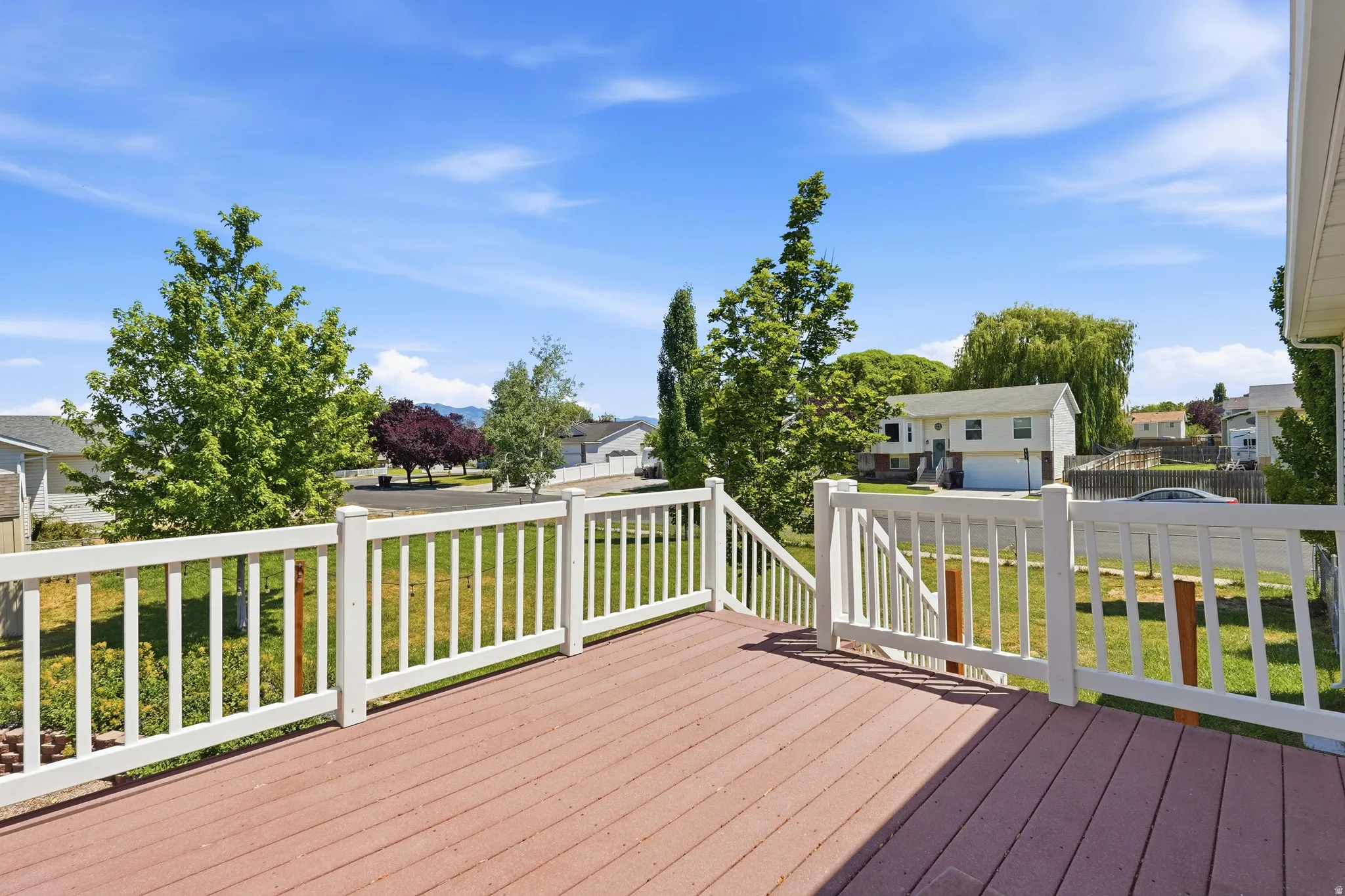 Spacious outdoor deck with composite decking and white railing, offering elevated outdoor living