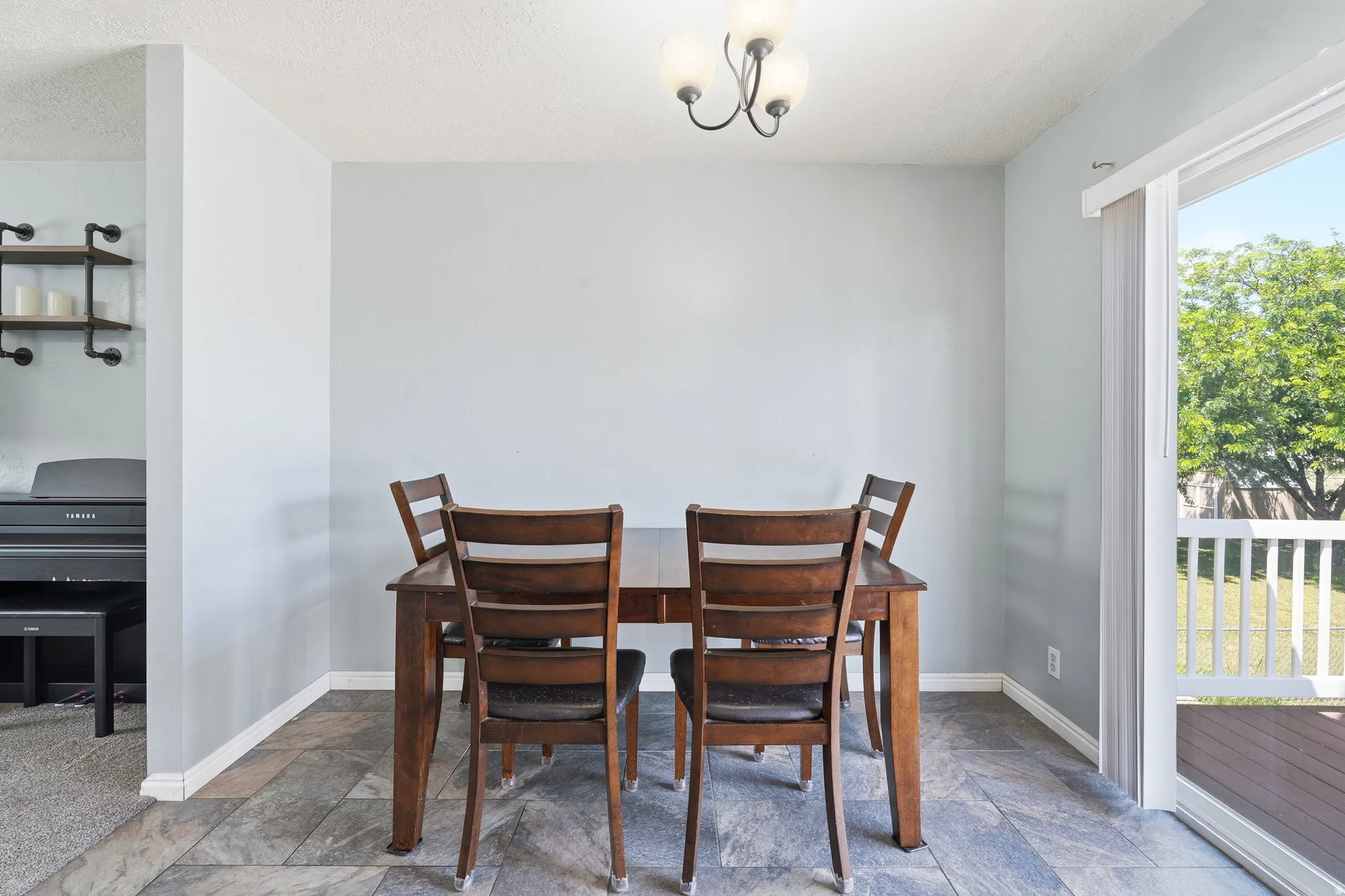 Dining area featuring slate-look tile flooring and a sliding glass door opening to an outdoor deck