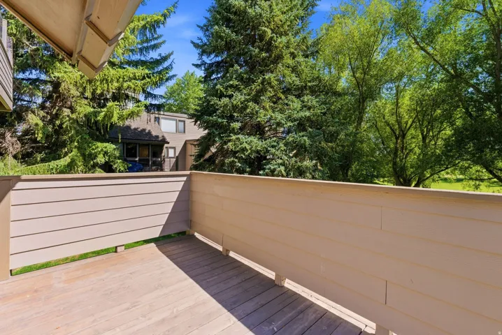 Outdoor deck featuring wood-finish flooring and light-toned horizontal railing