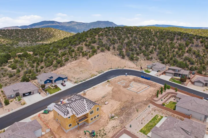 Newly paved street winding through a developing residential area with mountain scenery