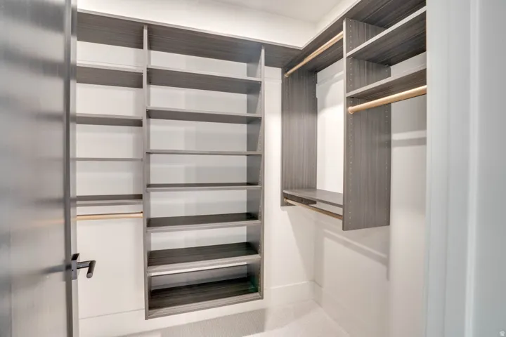 Custom closet system featuring dark wood-finish shelving and hanging rods