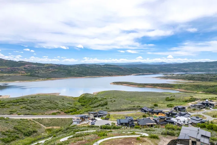 Expansive lake with surrounding green hills and distant mountains