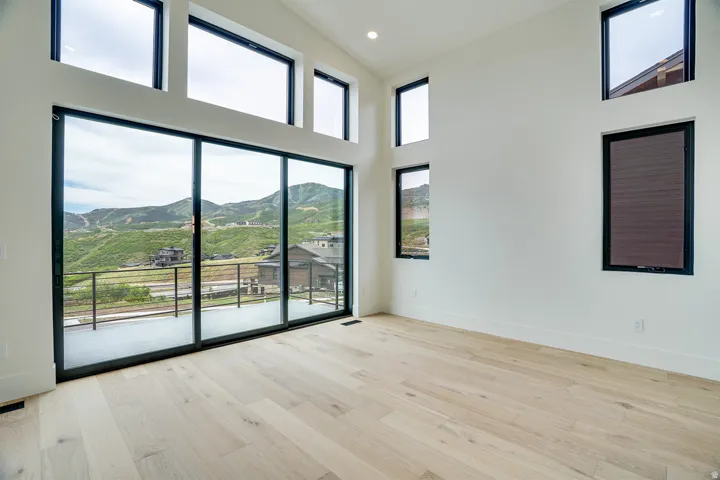 Expansive sliding glass doors open to a balcony with a metal railing