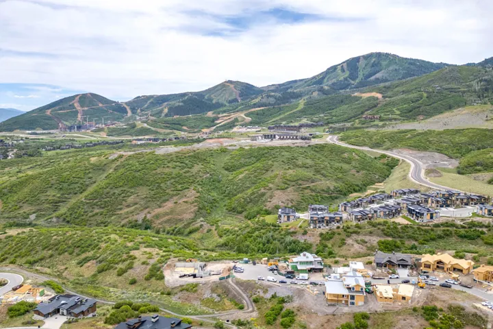 Expansive mountain landscape with diverse terrain, featuring multiple development sites and established residential clusters