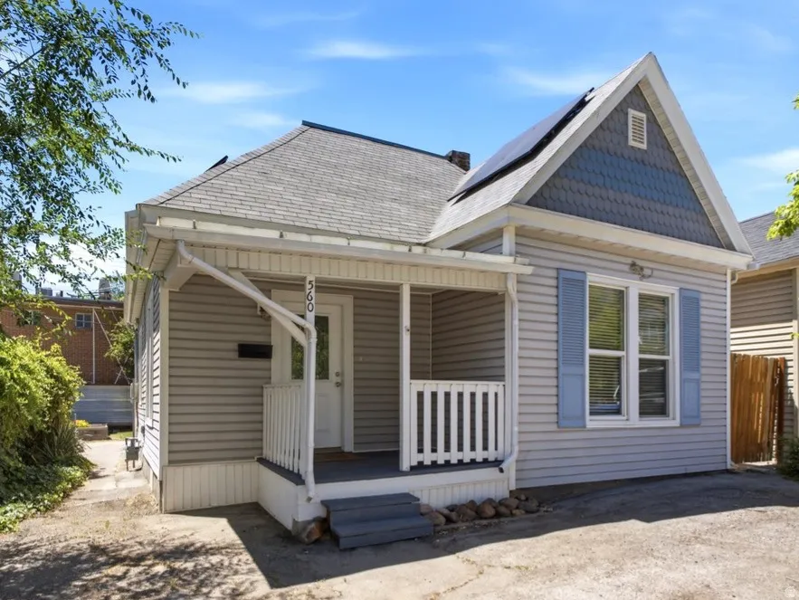 Siding exterior with a covered porch and white railing