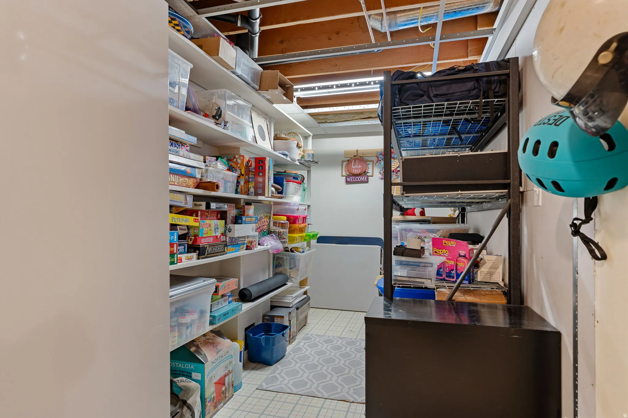 Open-concept utility space featuring exposed ceiling joists and integrated shelving units