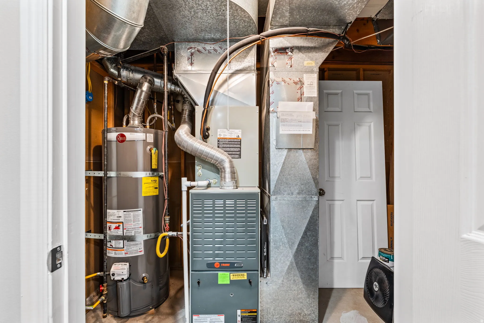 Utility closet featuring a water heater, furnace, and extensive ductwork