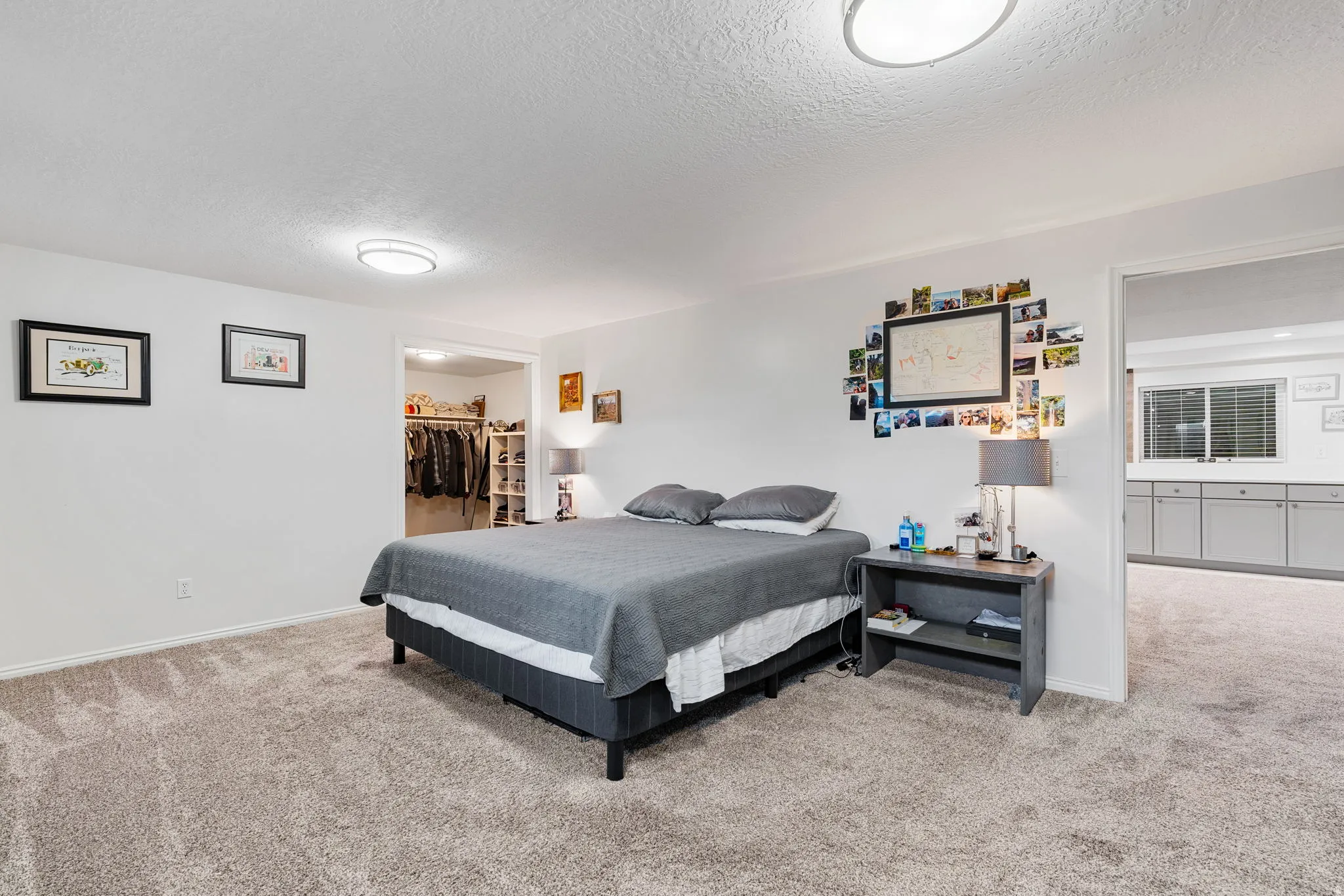 Carpeted room featuring a ceiling-mounted light fixture, recessed closet space, and a wide entryway to an adjacent space