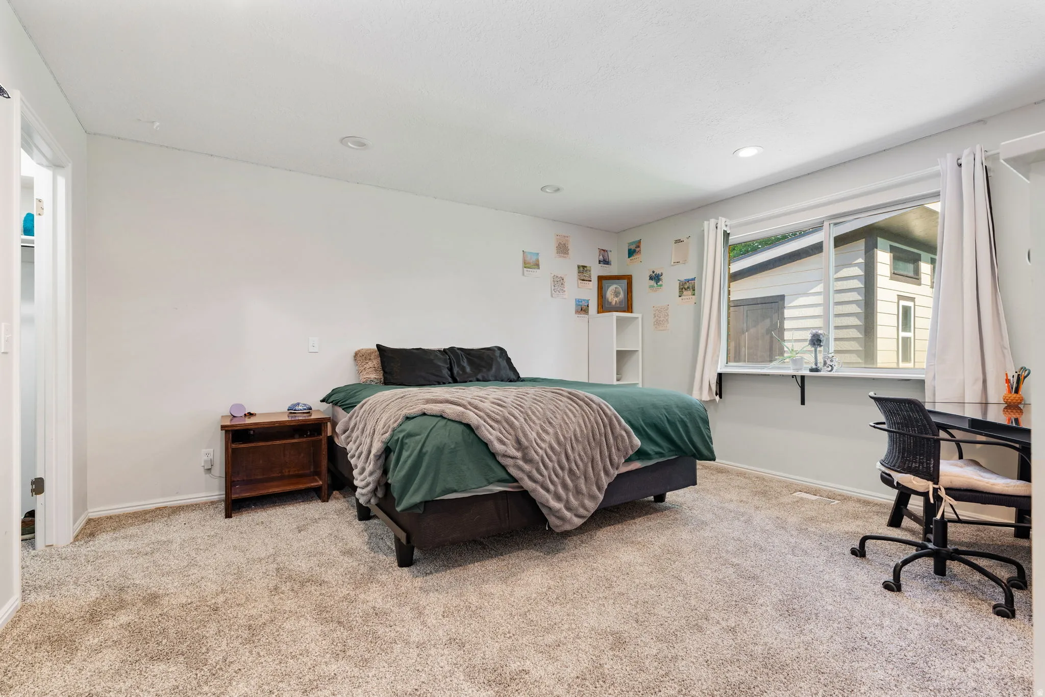 Carpeted interior room featuring light-colored walls and recessed lighting