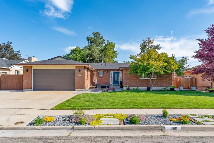 Brick exterior with an attached garage, featuring a dark wood-finish garage door