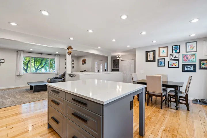 Kitchen island featuring a white countertop and gray cabinetry with dark hardware